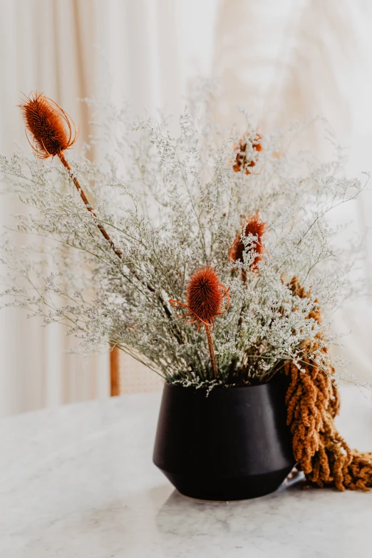 small dried flowers are in the black bowl