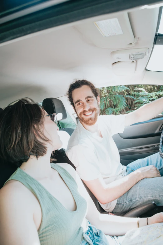 a couple of people in a car with a steering wheel