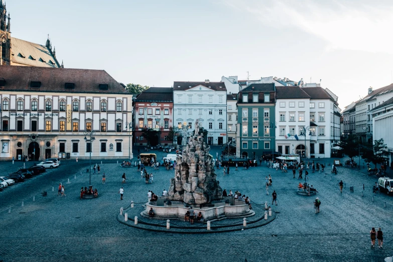 a statue in a city square surrounded by buildings