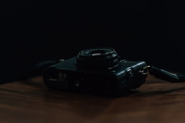 a camera with a black lens sitting on a wooden surface