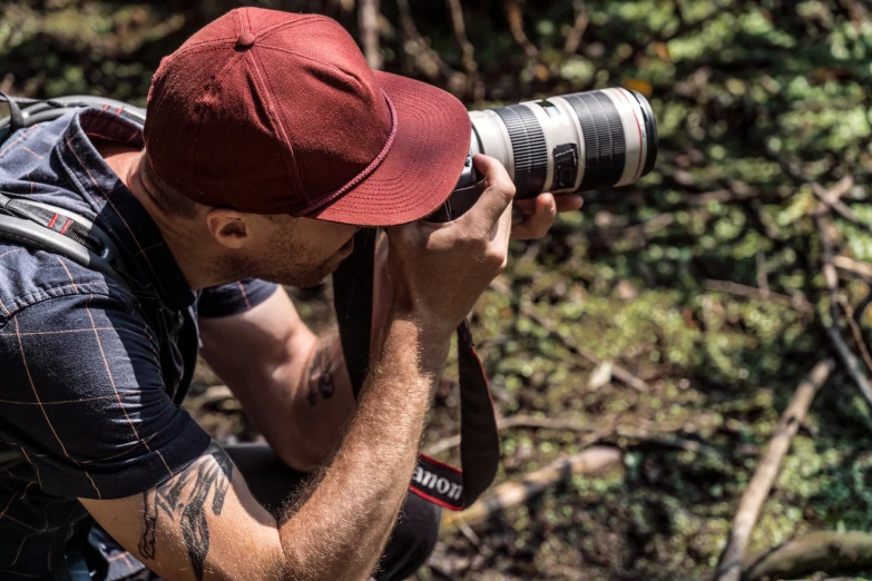 a man wearing a cap taking a po with his camera