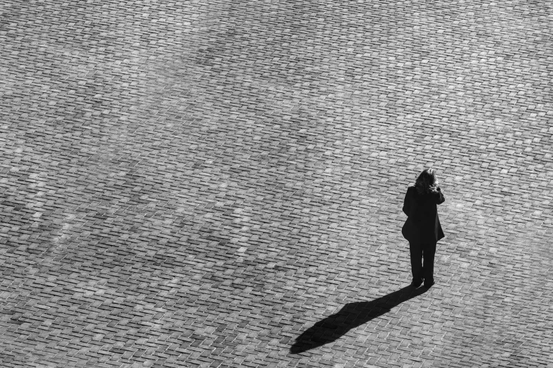 man on a bike with a large black umbrella standing by a skateboard