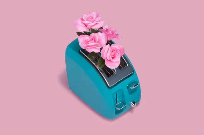 a blue toaster with pink flowers on top