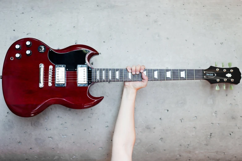 the guitar hanging from a wall by two hands