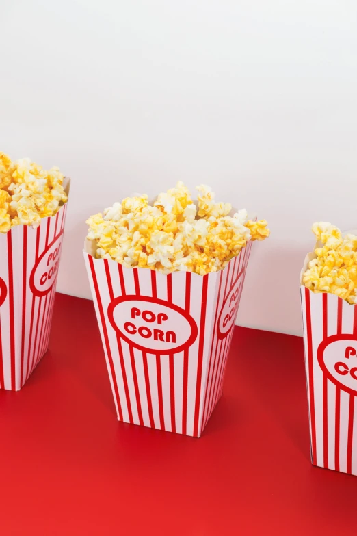 a row of popcorn bags full of popcorn on a red table