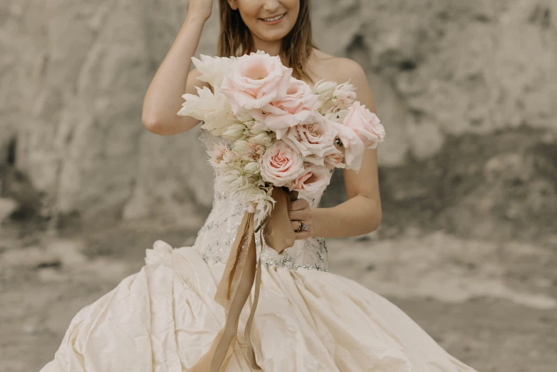 a woman in wedding gown posing holding flowers