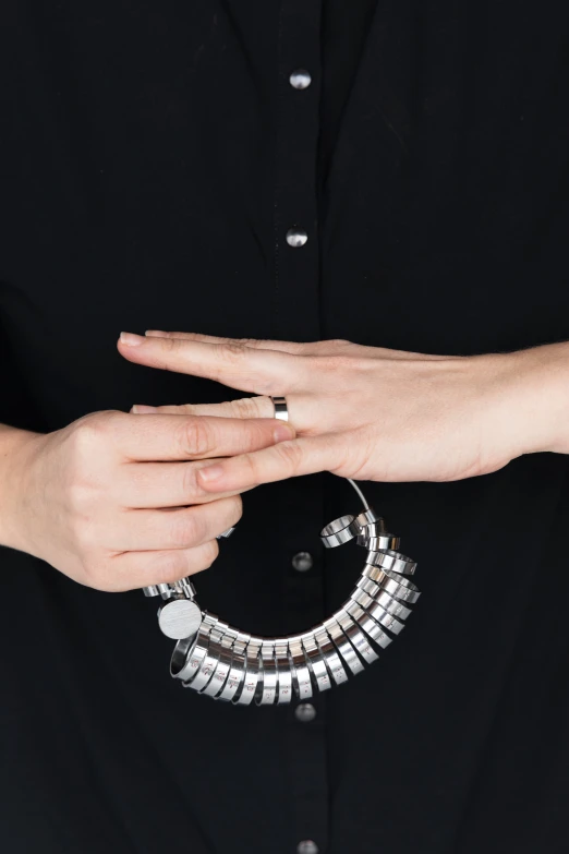 hands in ring made of metal beads and a chain