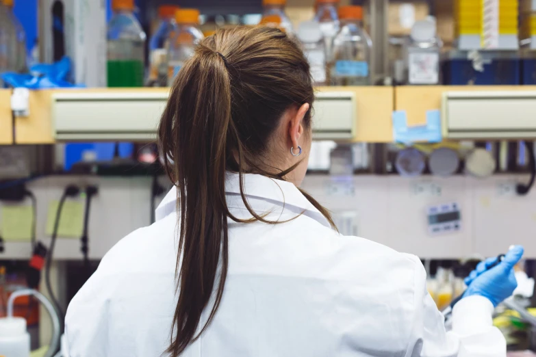 the girl in the lab is checking the blue substance