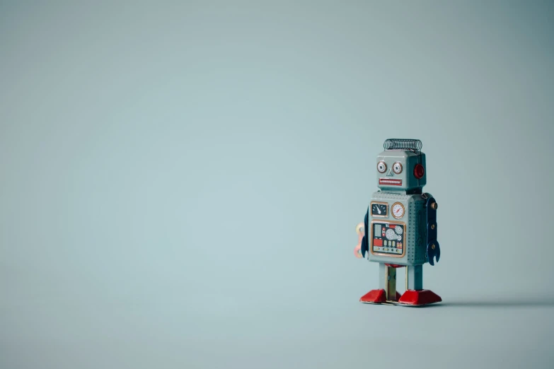 an old robot toy stands on two red legs