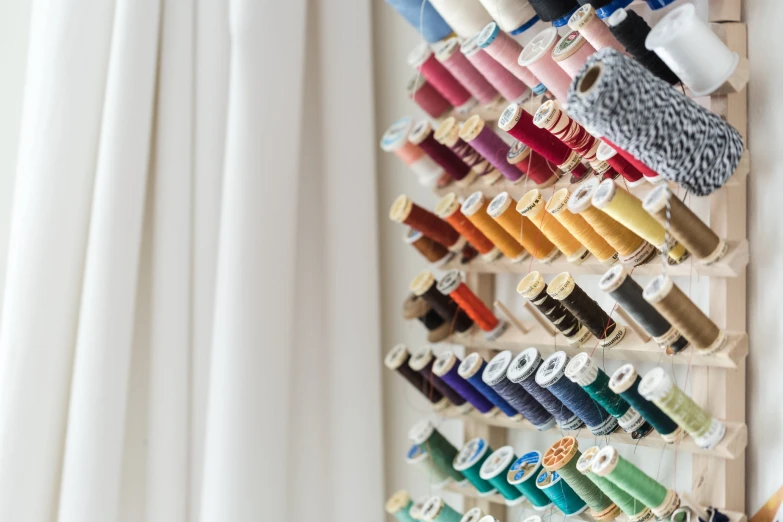 the wall is full of various colored shoes and thread