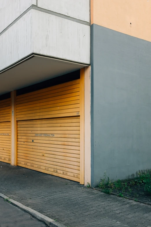 an empty garage with two doors on a sidewalk