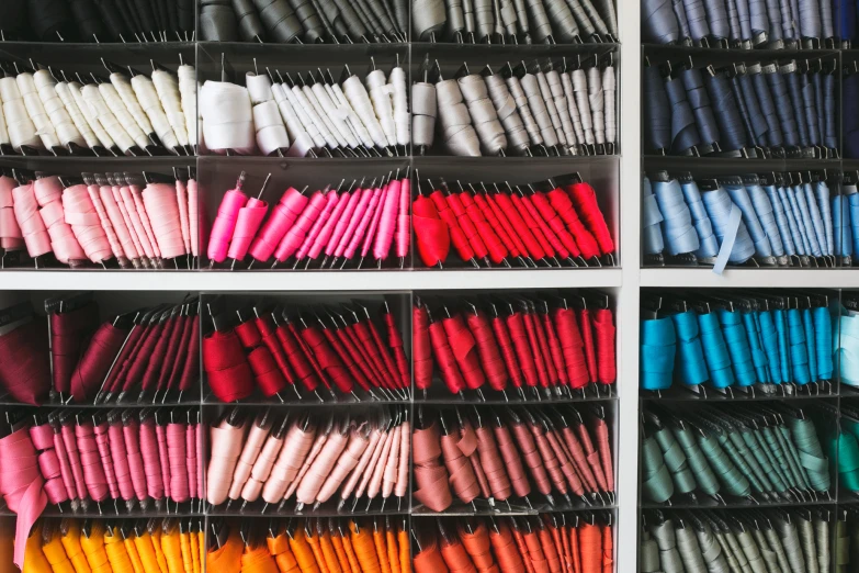 several shelves filled with a variety of different colored umbrellas