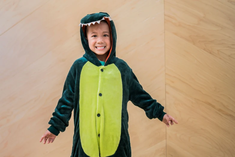a child standing with his arms open wearing a dragon costume