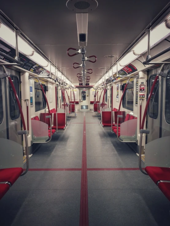 a subway car has some red and silver seats