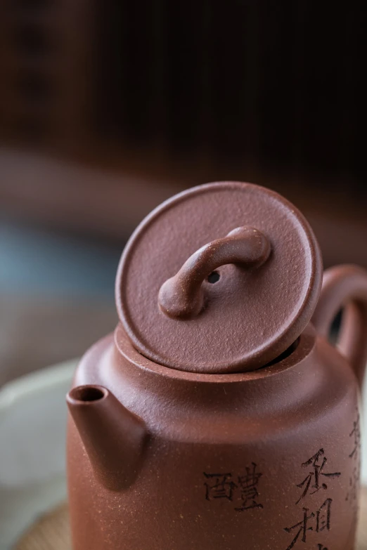 a brown tea pot with chinese writing on it