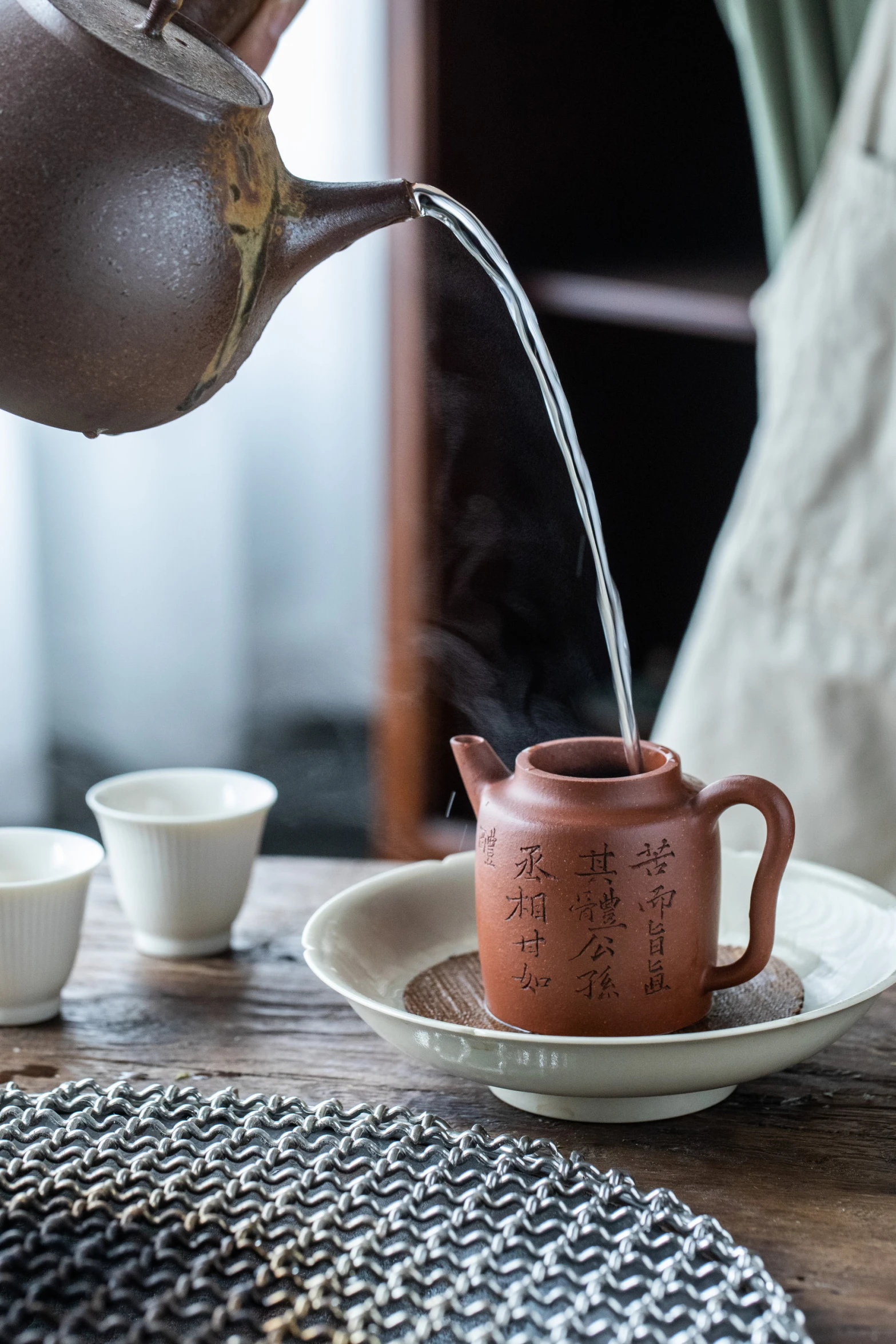 a tea kettle pouring water on to a cup