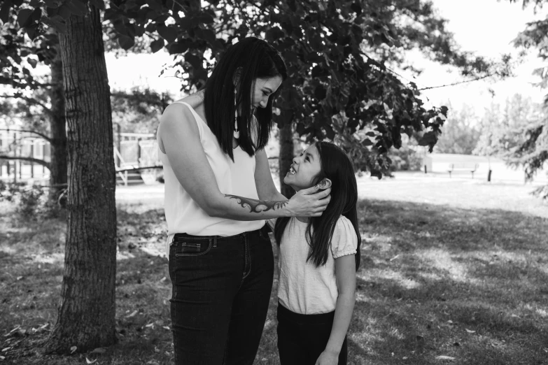 a mom is playing with her little girl in the park