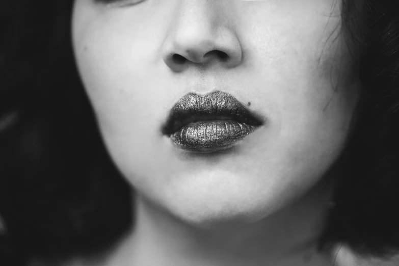 the young woman is wearing black lipstick and is looking away from the camera