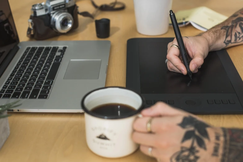 a man is using a laptop and holding a pencil