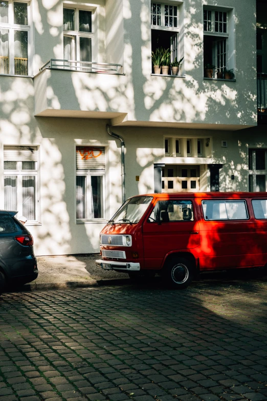 two cars parked in front of a very tall white building