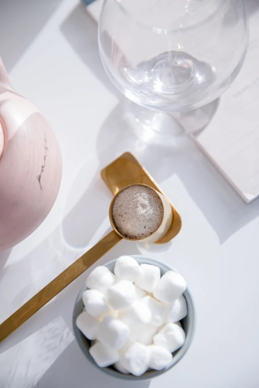 a mug, spoon, and sugar cube on a table