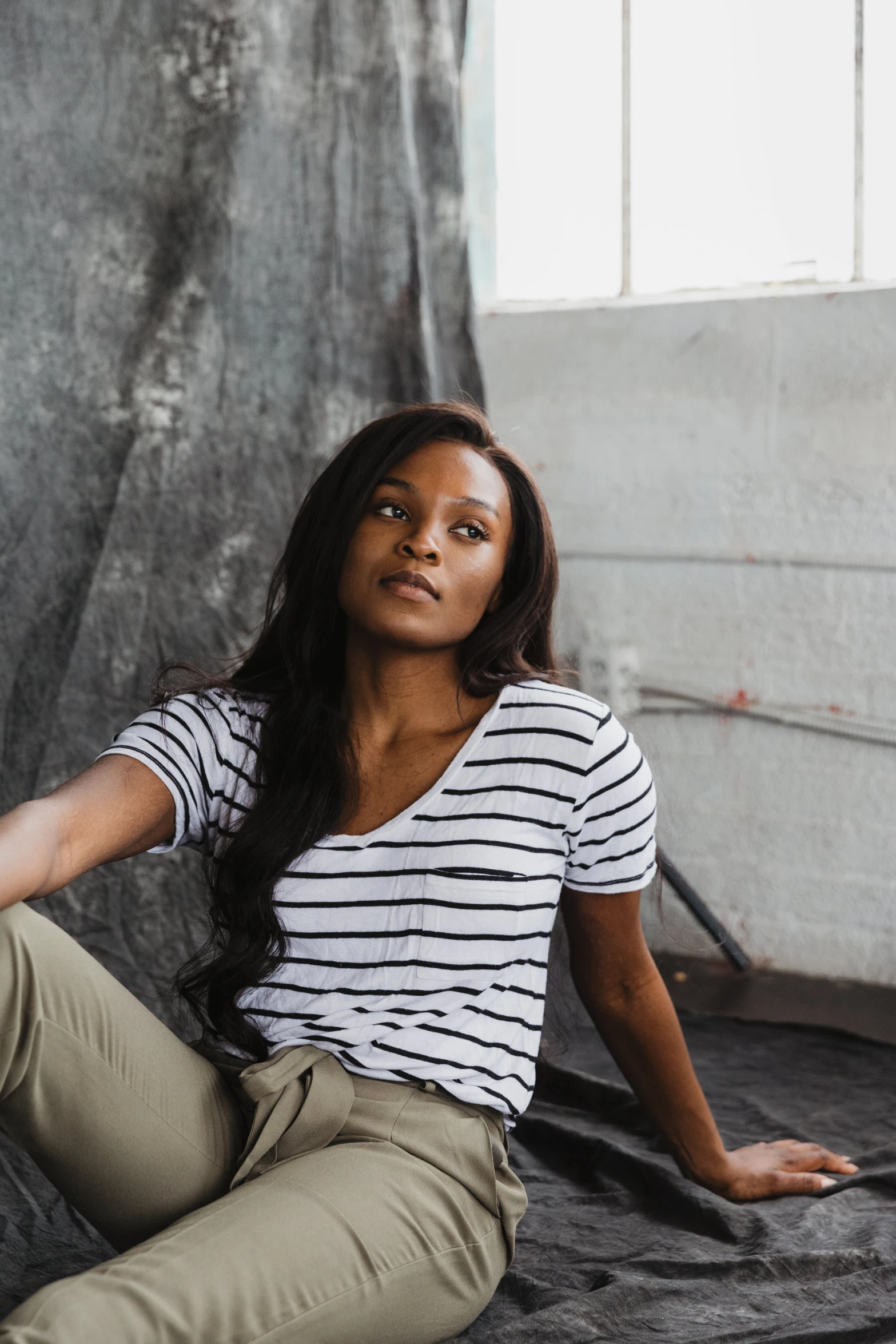 a woman sitting down wearing beige pants