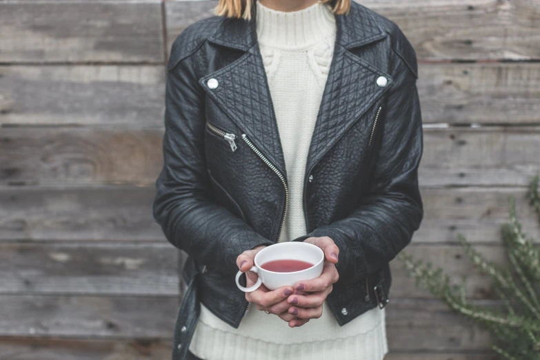 a woman is holding a cup in her hand