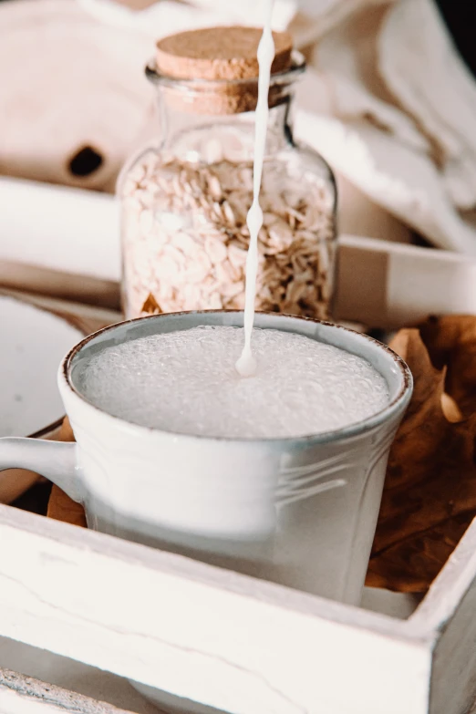 an empty white pitcher filled with milk on top of a table