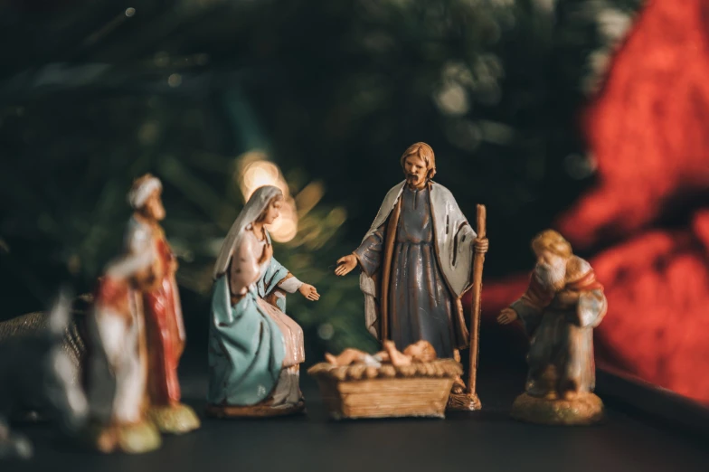 christmas ornaments displayed on table with nativity scene in background