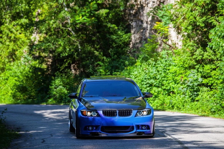 a bmw in front of some bushes and trees