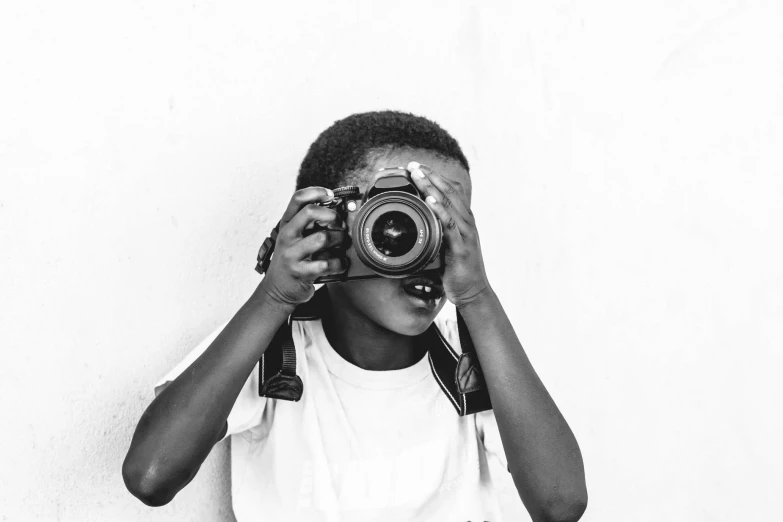 a little boy taking a po with a camera