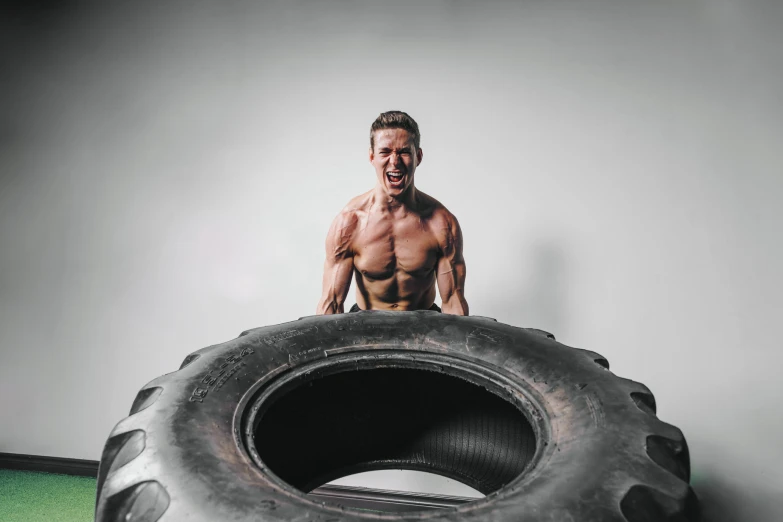 a man in the middle of a large tire