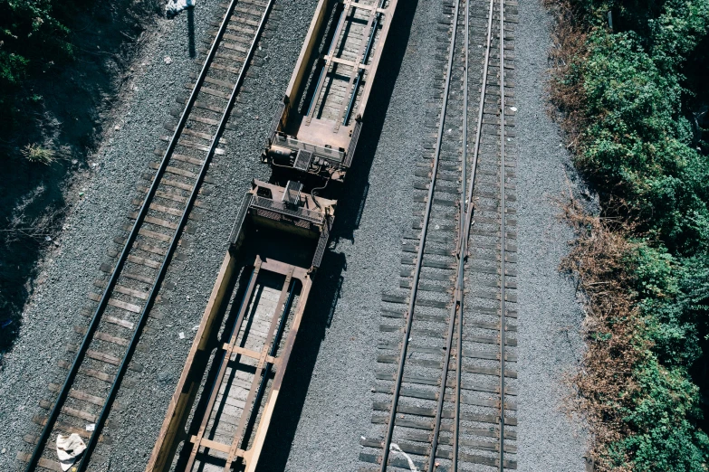 three railroad cars sit on the tracks next to some trees