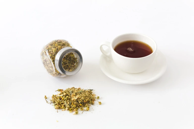 a cup of tea is next to a plate and a metal container