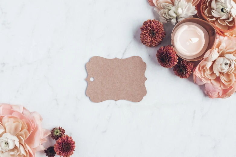 a candle and some pink flowers on a table