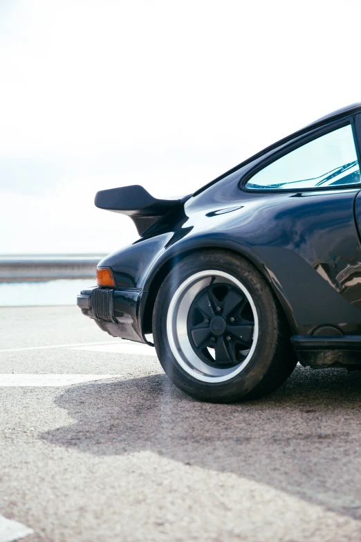 the back end of a gray car with wheels and rims