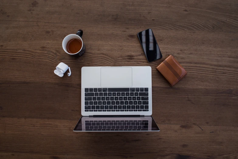 an open laptop computer sitting on top of a wooden table