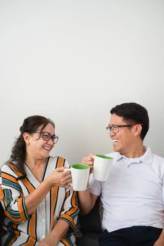 the man and woman are drinking from coffee cups