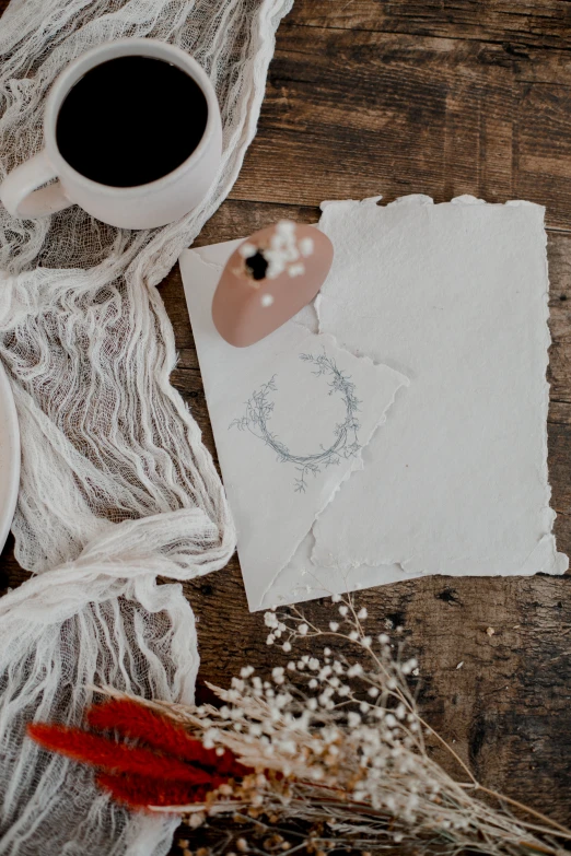 a cup of coffee, scissors and paper with a piece of wax paper taped to it