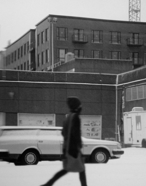 two people walking in a parking lot next to a large building