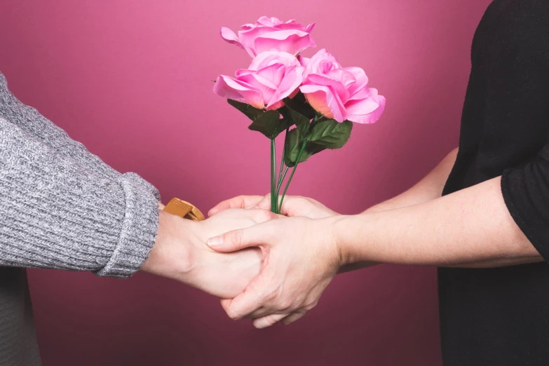 a person holds a small bouquet of roses