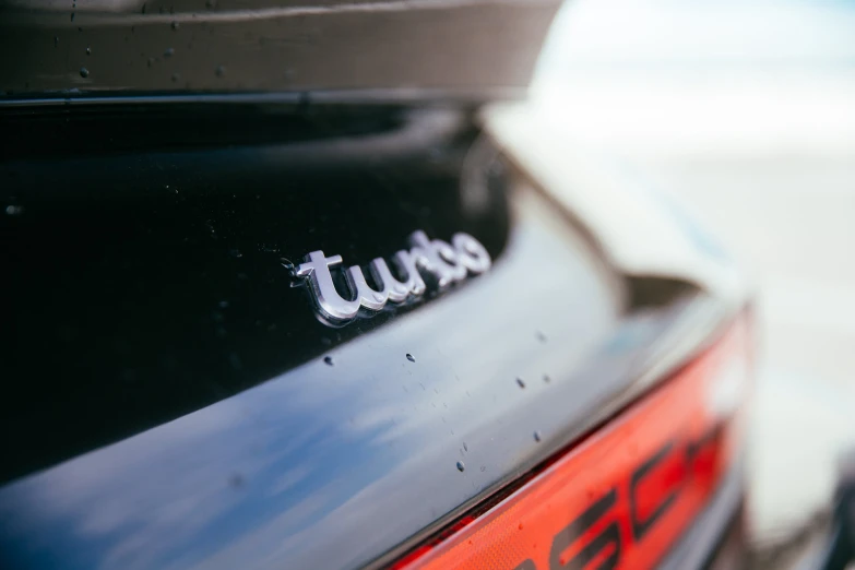 the back view of a parked cars trunk with lettering