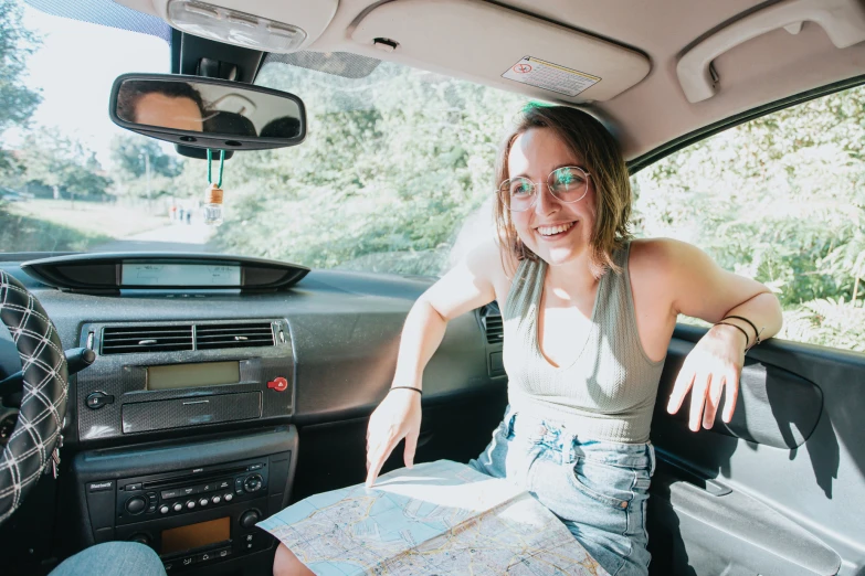 a woman sits inside a car, looking out the window