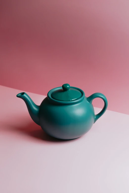 a tea pot with a handle and a round, wooden cover on a pastel surface