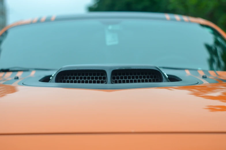 the front end of an orange car is seen