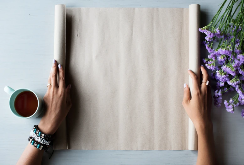 two hands holding a paper roll and holding a cup