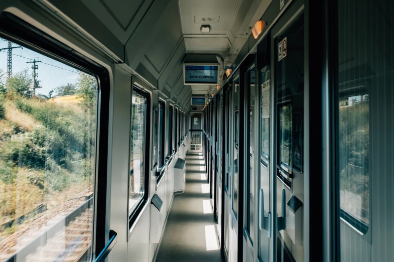 the inside view of a train looking towards mountains