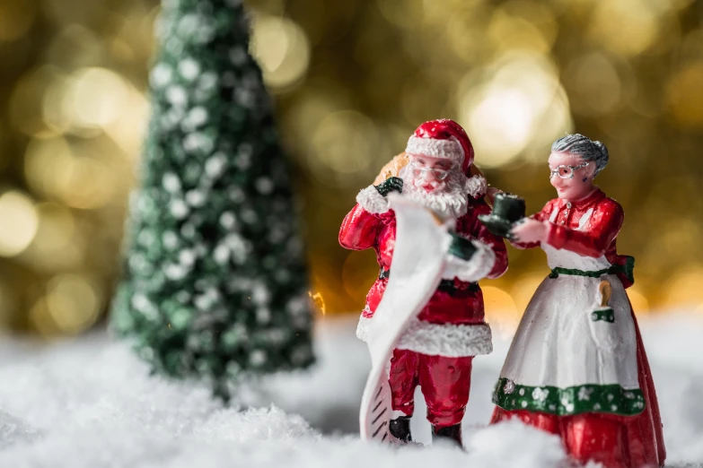 two miniature figures in santa outfits in the snow
