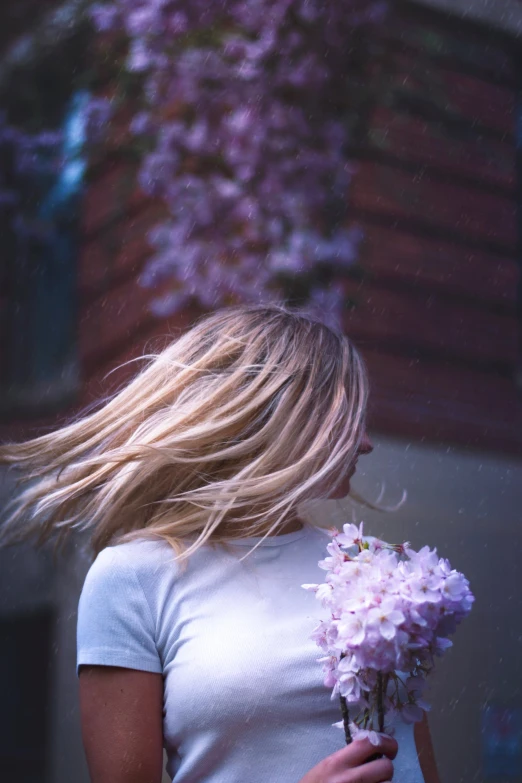 a woman walking down a sidewalk with flowers in her hair