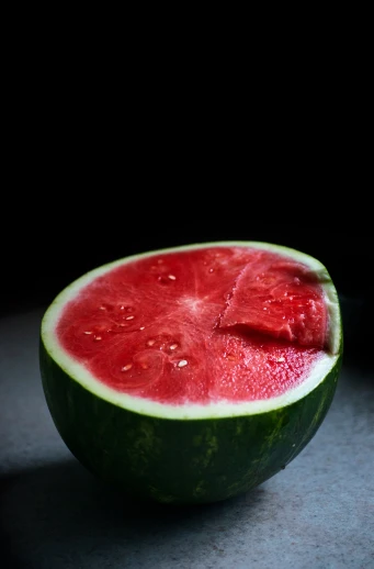 a watermelon sliced into three pieces in the dark